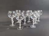 six clear wine glasses lined up in a row on a black surface