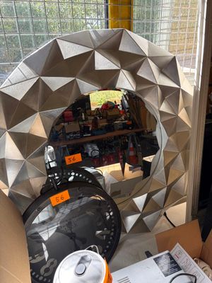 un miroir posé sur une table devant une fenêtre
