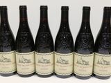 six bottles of wine are lined up in a row on a table