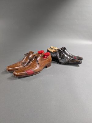 two pairs of men ' s shoes with red bows on them