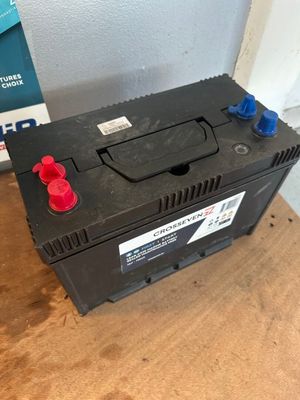 un gros plan d'une batterie de voiture posée sur une table en bois