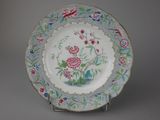 a plate with a floral design on it on a stand