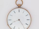 une montre de poche en or avec des chiffres romains sur le cadran