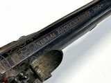 an old gun that is on display on a white surface