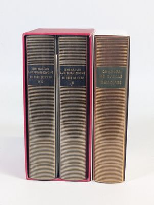 trois livres dans une boîte rose posée sur une surface blanche