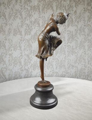 une statue en bronze représentant une femme, posée sur un socle