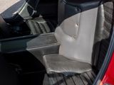 the interior of a red car with the door open and the seat up