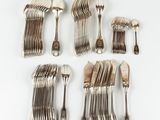 several silverplated forks and spoons laid out on a white surface