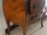 a marble top chest of drawers in the corner of a room