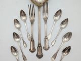 un grand nombre de cuillères et de fourchettes en argent disposées en cercle