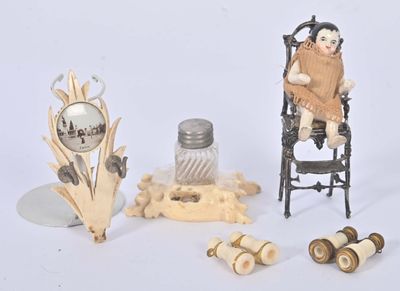 a small doll sitting in a chair next to other items