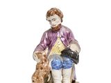 a figurine of a man sitting on a bench with a dog