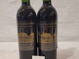 deux bouteilles de vin posées sur une table, à côté d'une étiquette de prix