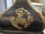 a black and gold clock sitting on top of a marble table