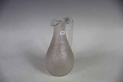 un vase en verre entouré d'une chaîne, posé sur une surface blanche