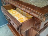 a wooden dresser with a marble top and drawers