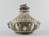 an antique silverplated sugar dish with a bird on top