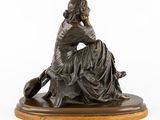 an image of a bronze statue of a woman sitting on a stool