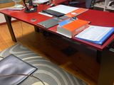 a red desk with a black chair in the corner
