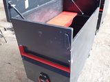 a black metal box with a red handle on it