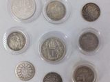 six types de pièces différents, rangés dans des étuis en plastique posés sur une surface blanche