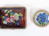une petite boîte ornée d'une peinture, à côté d'une autre petite boîte ornée d'une peinture