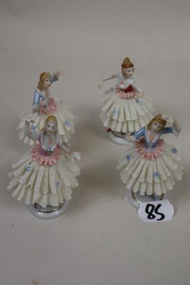 three porcelain figurines of a woman in a dress and a man in a tutu