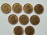 six different british coins are arranged in a circle on a white surface
