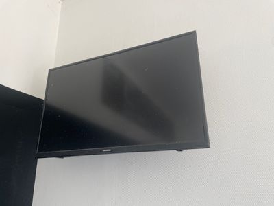une télévision à écran plat fixée au mur dans un coin de la pièce