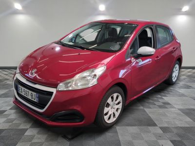 une voiture rouge est garée dans une pièce au sol en damier