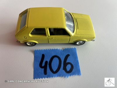 une petite voiture jaune posée à côté d'un tissu bleu