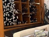 a lot of silverware in a wooden cabinet