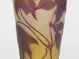 vase en verre violet et jaune orné de feuilles sur un fond blanc