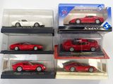 six petites voitures rouges et blanches dans une vitrine