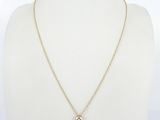 a gold necklace with a small white diamond on a gold chain