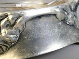 a close up of a silver spoon with a cat on it