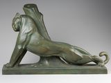 une statue en bronze représentant un lion couché sur le dos