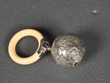 a bead and a ring on a black surface