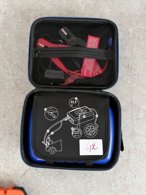 une valise noire sur laquelle est dessiné un voiture et une paire de chaussures orange