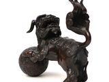 a statue of a dog with a ball in it ' s mouth