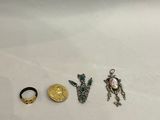 trois anneaux et un anneau orné d'une pièce d'or sur un fond blanc
