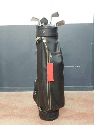 a bag of golf clubs on the floor next to a wall