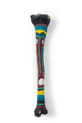 a close up of a wooden stick with a face on it