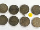 a group of old coins sitting on top of a white surface