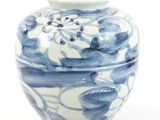 un vase bleu et blanc posé sur une surface blanche