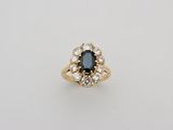 an oval sapphire and diamond cluster ring in yellow gold