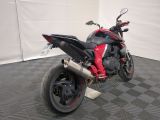 a red and black motorcycle parked in a garage