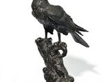 statue représentant un oiseau perché sur une souche d'arbre, sur fond blanc