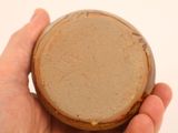 a person holding a small brown bowl in their hand