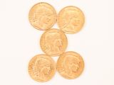 four gold coins are arranged in a pyramid on a white surface